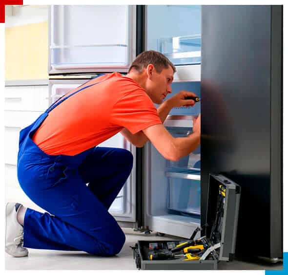 Tecnico em refrigeracao ajustando uma geladeira com ferramentas